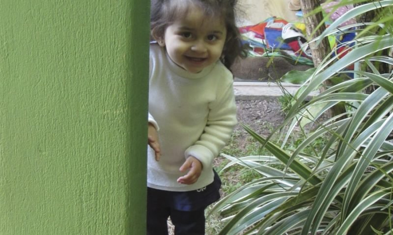 Com quantos meses o bebê começa a andar - Criança caminhando pelo gramado
