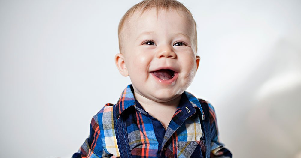 bebê sorrindo com camisa xadrez - marcos do desenvolvimento infantil