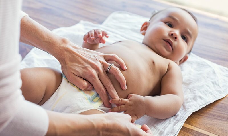 mãe trocando a fralda do seu bebê - momento para iniciar o desfralde