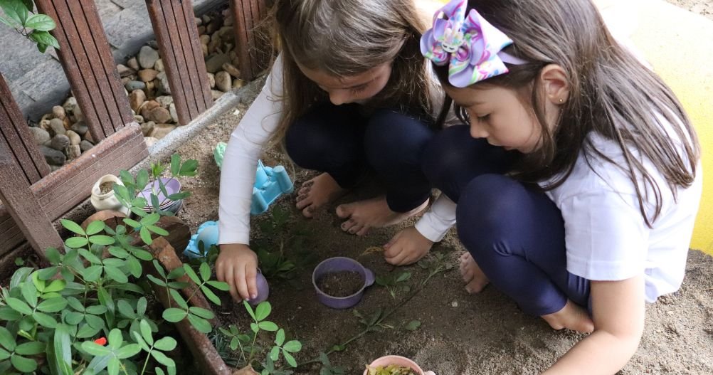 duas crianças brincando no jardim - Autonomia Infantil
